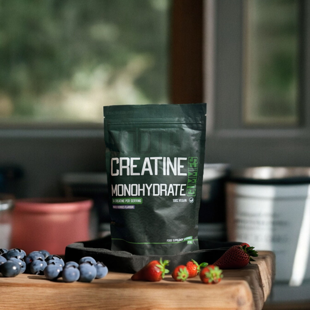 nootras creatine monohydrate gummy pouch standing in a kitchen with strawberries and blueberrie saround it