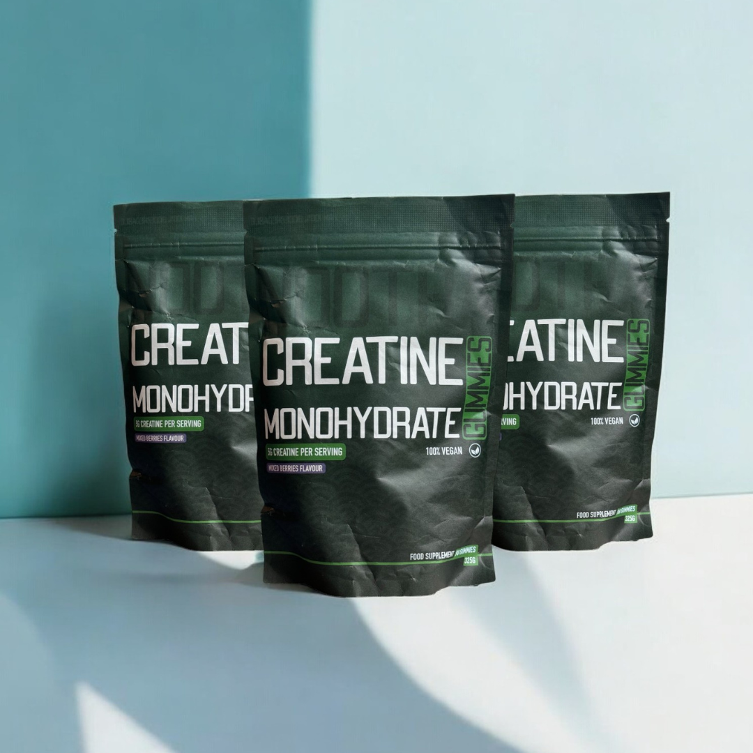 three pouches of nootra creatine gummies against a blue background